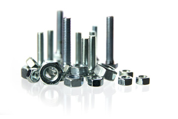 nuts and bolts standing like a skyline with long reflections on white