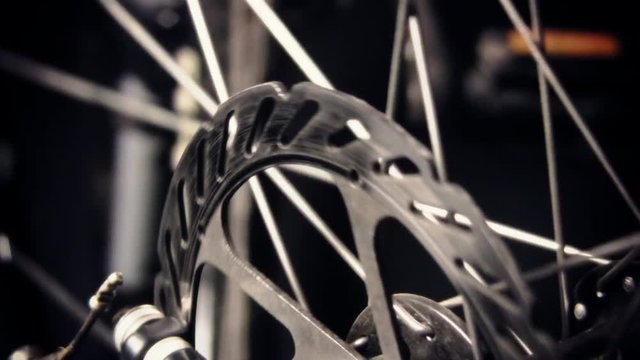 A close up shot of a bicycle wheel spinning with slotted disc brakes. HD 1080p.