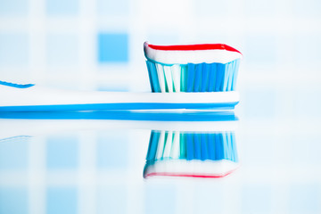 toothbrush with red stripe toothpaste and mirror reflection