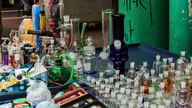 Man Arranges Hookahs Jars on Mobile Counter in Street