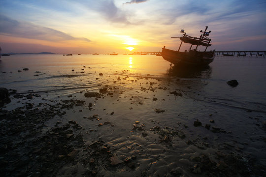 Silhouette natural background of small fishing boats moored beached on the beach during time the sunset and the beautiful natural of the colorful sky at BangPhra beach , Chonburi province in Thailand