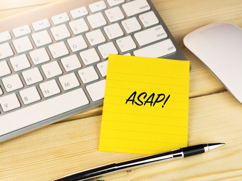 ASAP on sticky note on wood work table
