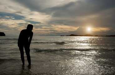 Fototapeta premium Young woman in summer dress standing on a rock and looking to a
