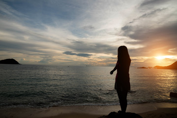 Fototapeta premium Woman silhouette on the beach at sunrise