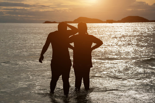 Couple silhouette breaking up a relation on the beach at sunset