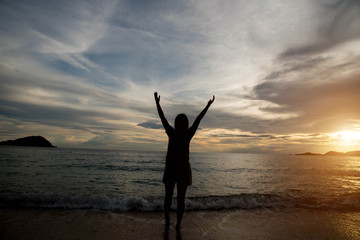 Fototapeta premium Woman silhouette on the beach at sunrise