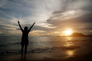 Fototapeta na wymiar Woman silhouette on the beach at sunrise