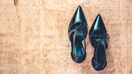 Black high heel shoes on grungy wooden background