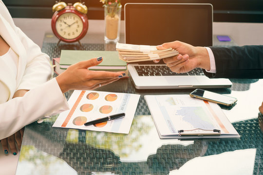 A Business Woman And A Businessman Hold Money