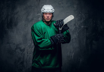 Obraz premium Hockey player in protective clothes holds playing stick.