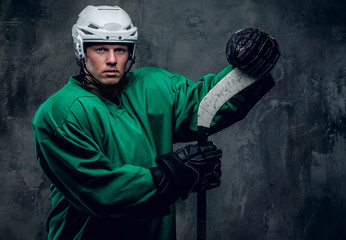 Naklejka premium Hockey player in protective clothes holds playing stick.