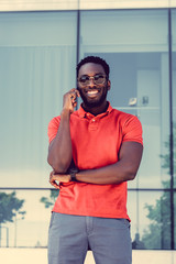 African male in red shirt using a smartphone.