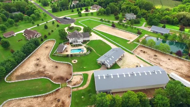 Country ranch, mansion with horse barns,pens,pool, aerial view.
