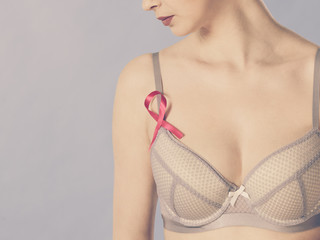 woman in bra with breast cancer awareness ribbon