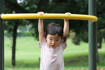 鉄棒にぶら下がる一歳児