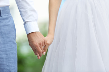 Bride and groom holding hands together outdoor