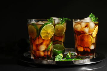 Metal tray with cuba libre cocktails on dark background