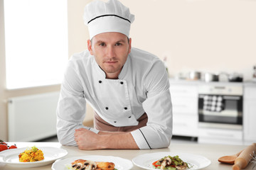 Young chef cook with different dishes in kitchen