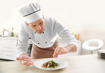 Young chef cook decorating dish in kitchen