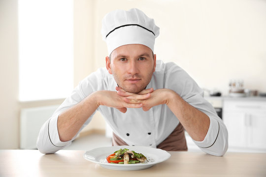 Young chef cook and tasty dish in kitchen