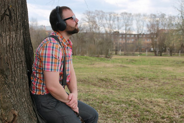 beard man with listen music in the park