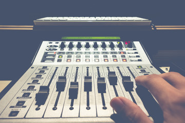sound engineer hand on digital music studio mixer for recording or radio / tv broadcast background
