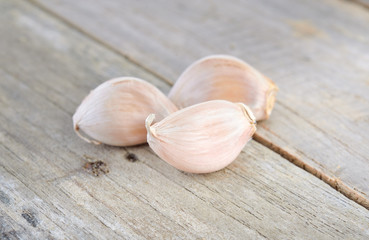 uncooked garlic with shell on wooden table