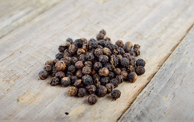 pile of dried black pepper grain on wooden table