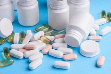 Many pills and tablets isolated on light blue background