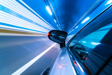 Speedy car driving in tunnel.