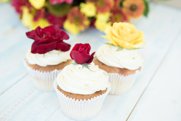 Three cupcakes with red and yellow roses. Selective focus