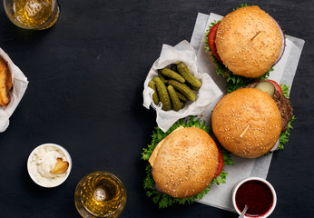Different burger with pickles, ketchup, mayonnaise, fries and li