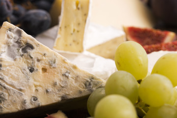 Assortment of cheese with fruits and grapes