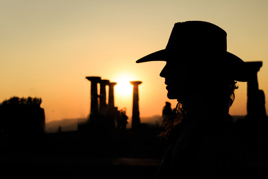 Girl with a cowboy hat at sunset