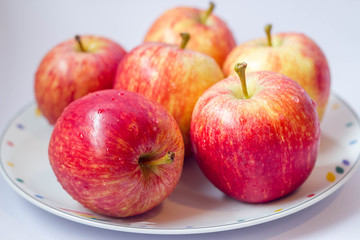 Fototapeta na wymiar group of fresh red apples on white dish