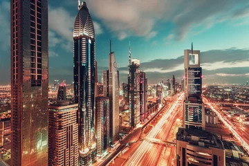 Foto op Canvas Bright colorful urban landscape of a big modern city with illuminated skyscrapers. Aerial view over downtown Dubai, UAE, with the famous highway. Artistic travel and architectural background. © Funny Studio