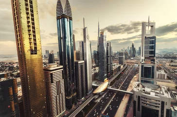 Zelfklevend Fotobehang Scenic skyline of a big futuristic city with world tallest skyscrapers. Aerial view over downtown Dubai, UAE. Artistic travel and architectural background. © Funny Studio