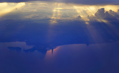 Golden light rays sunset Shining through rich in space clouds ,over the ocean.