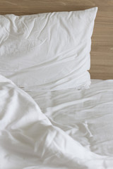 Messy white bed and two pillow, in the morning.