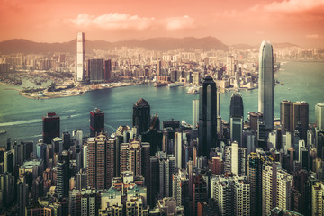 Scenic skyline of a big modern city with skyscrapers. View over the harbour from Peak Victoria in Hong Kong, China. Vintage effect.