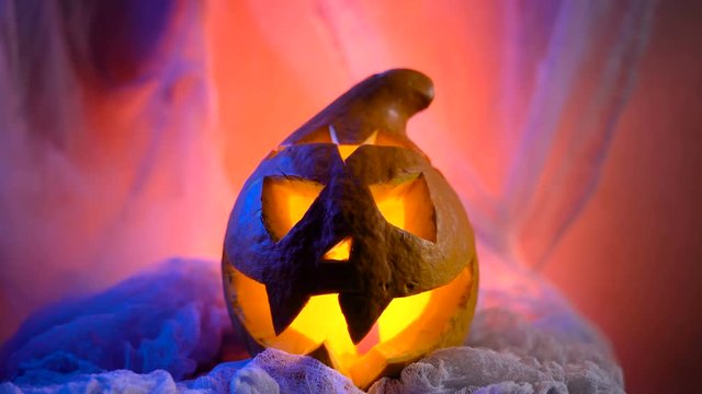 Scary Halloween Pumpkin looking through the smoke. Glowing, smoking monster pumpkin from depths of hell