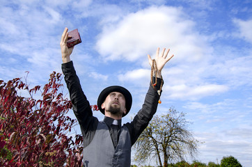 Young bearded priest with hands lifted to sky