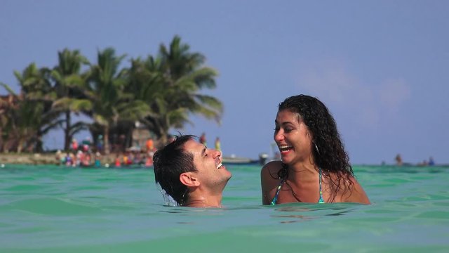 Woman Wearing Bikini With Man Floating In Water