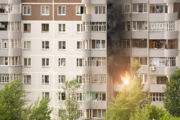 Fire with black smoke in multistory apartment building