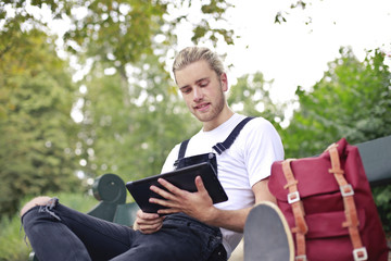 Obraz premium Handsome young man sitting at the park