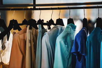 Clothes on racks in a fashion boutique - obrazy, fototapety, plakaty