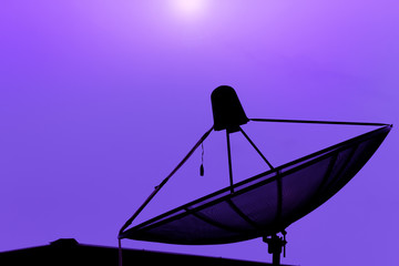 Communication satellite dish on the roof with sunset sky backgro