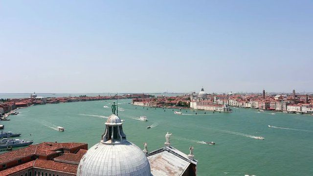 Boats navigating along the Grand Canal in Venice with the San Gorgio Cathedral in the foreground and the San Marco plaza on the right in Italy famous city. 