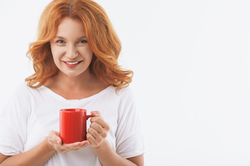 Joyful senior lady enjoying hot drink