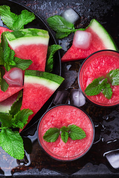 Watermelon slices drink smoothie with mint on grunge table